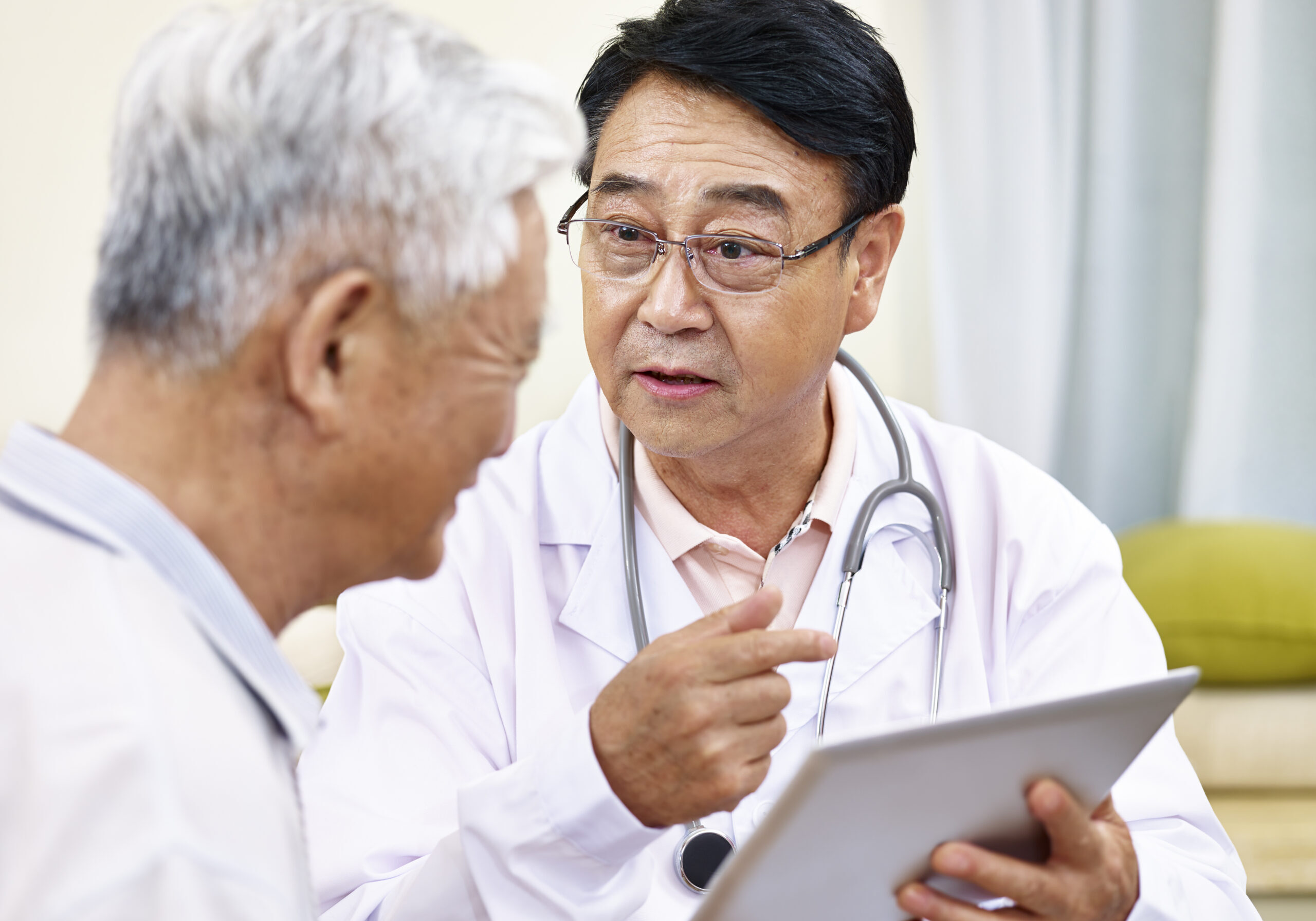 asian doctor explaining health condition to a senior patient