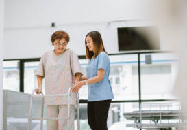 young physical therapist helping senior patient in using walker during rehabilitation young physical therapist helping senior patient in using walker during rehabilitation